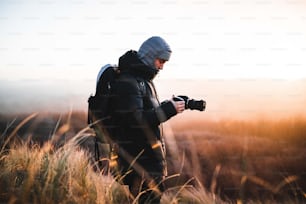 Un homme debout dans un champ avec une caméra