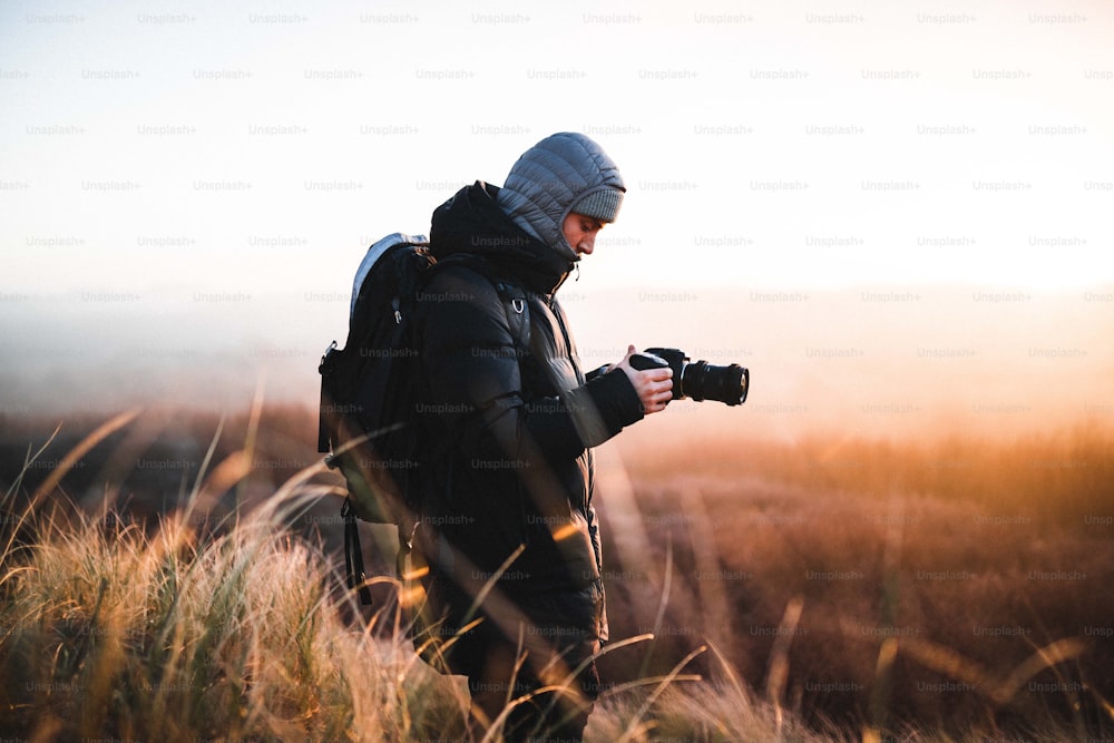 a man standing in a field with a camera