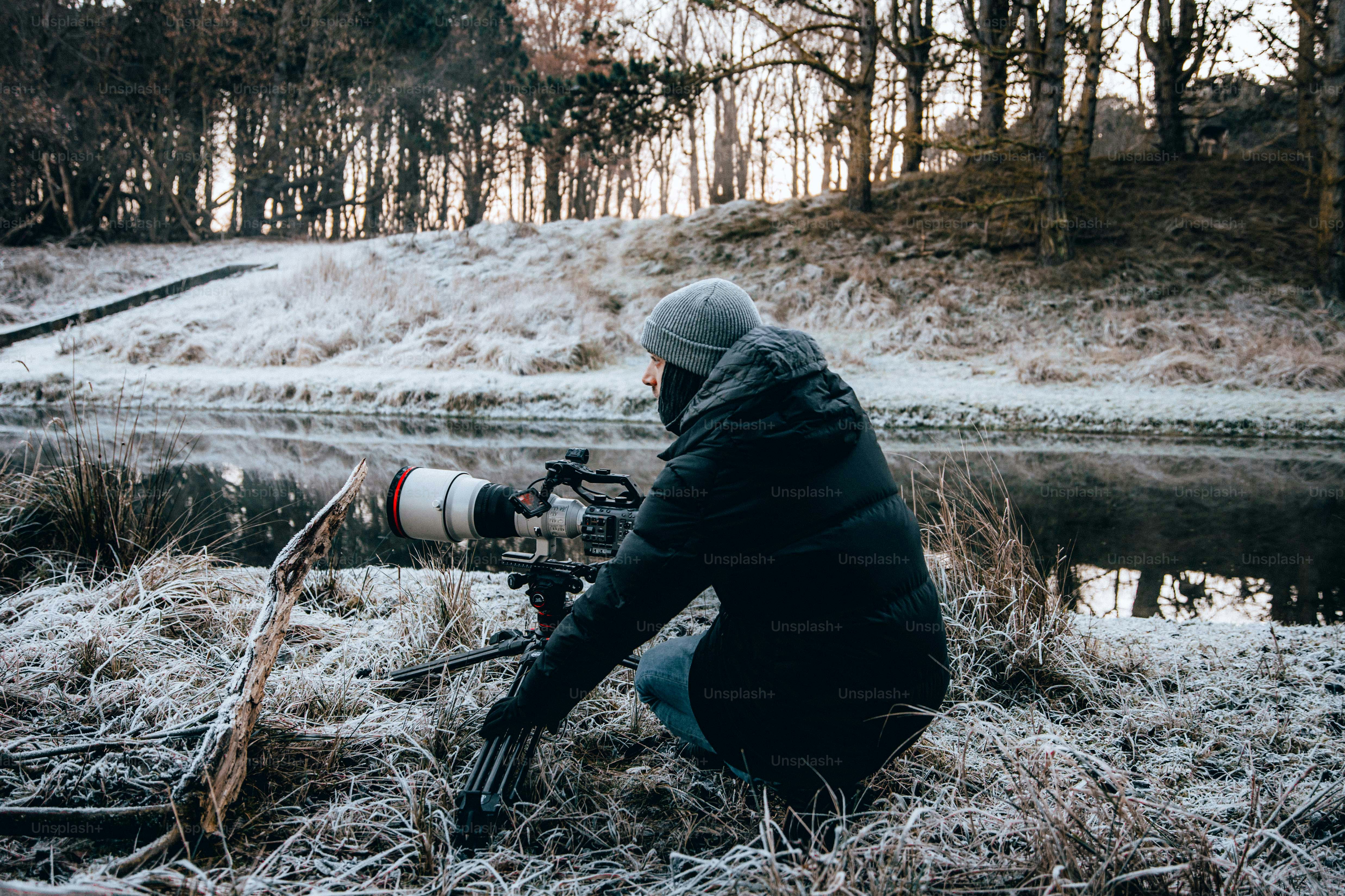 a man kneeling down with a camera in his hand