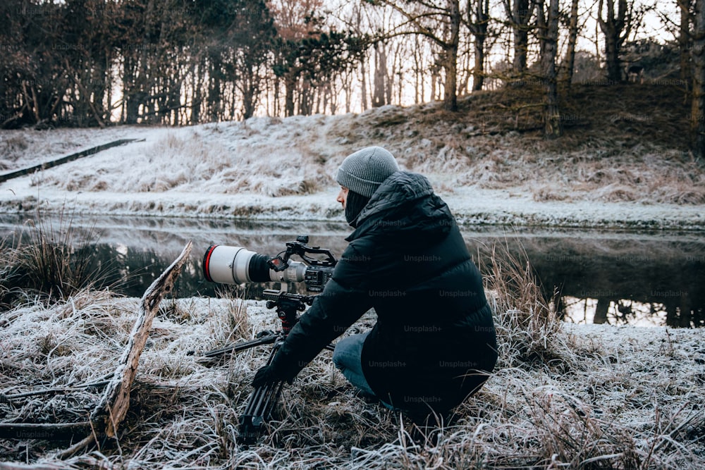 a man kneeling down with a camera in his hand