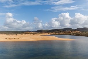 un plan d’eau entouré de collines et de nuages