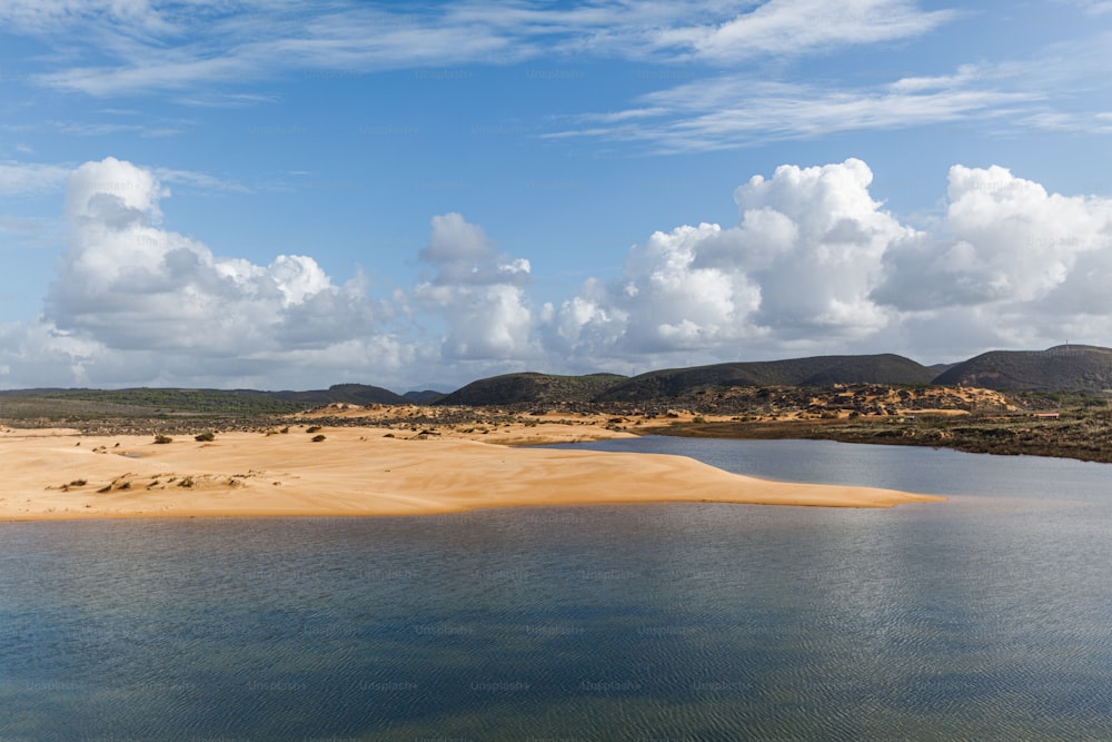 a body of water surrounded by hills and clouds