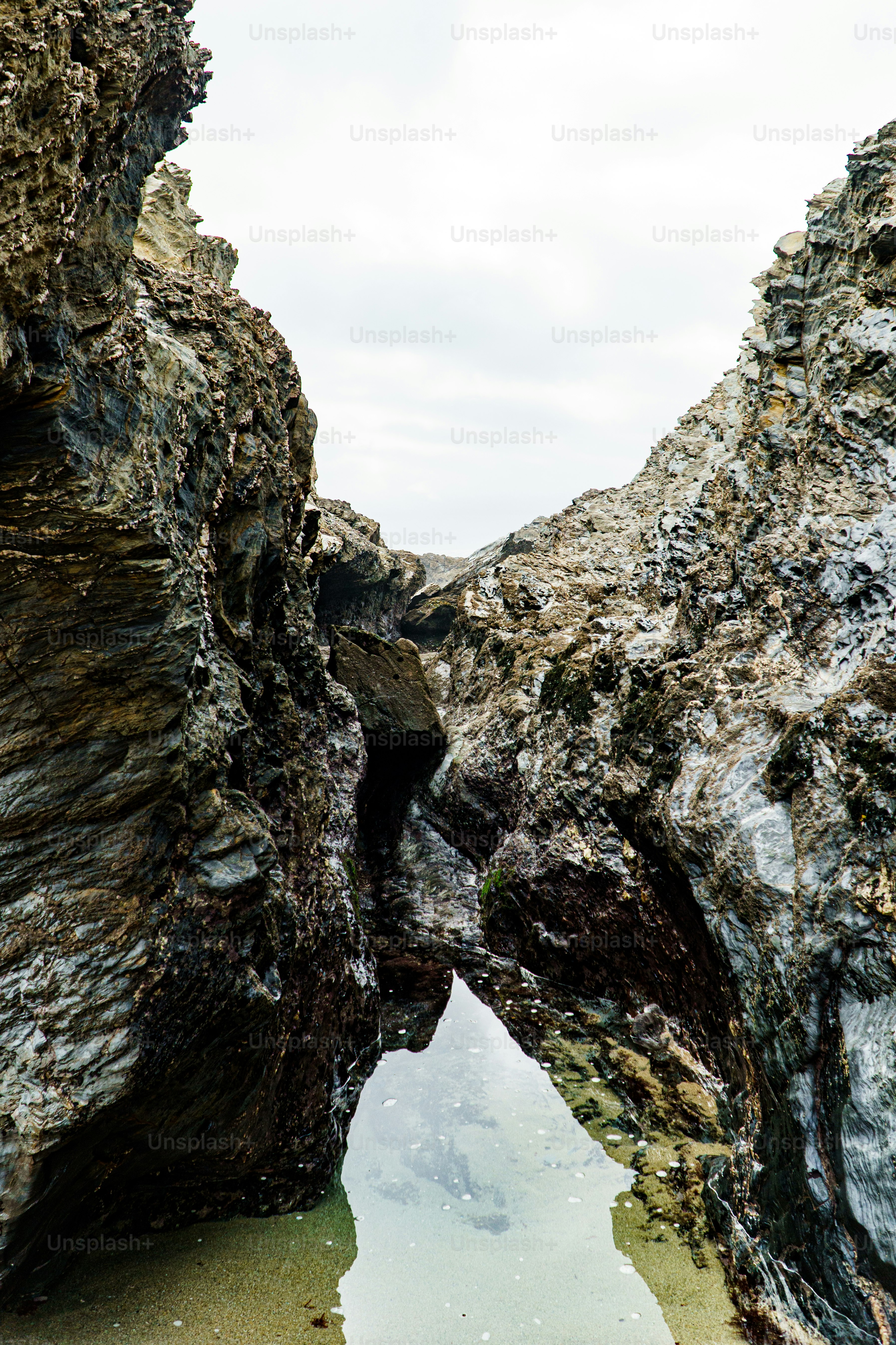 a rocky beach with a small pool of water