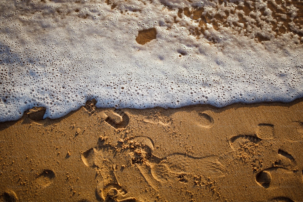 a sandy beach with footprints in the sand