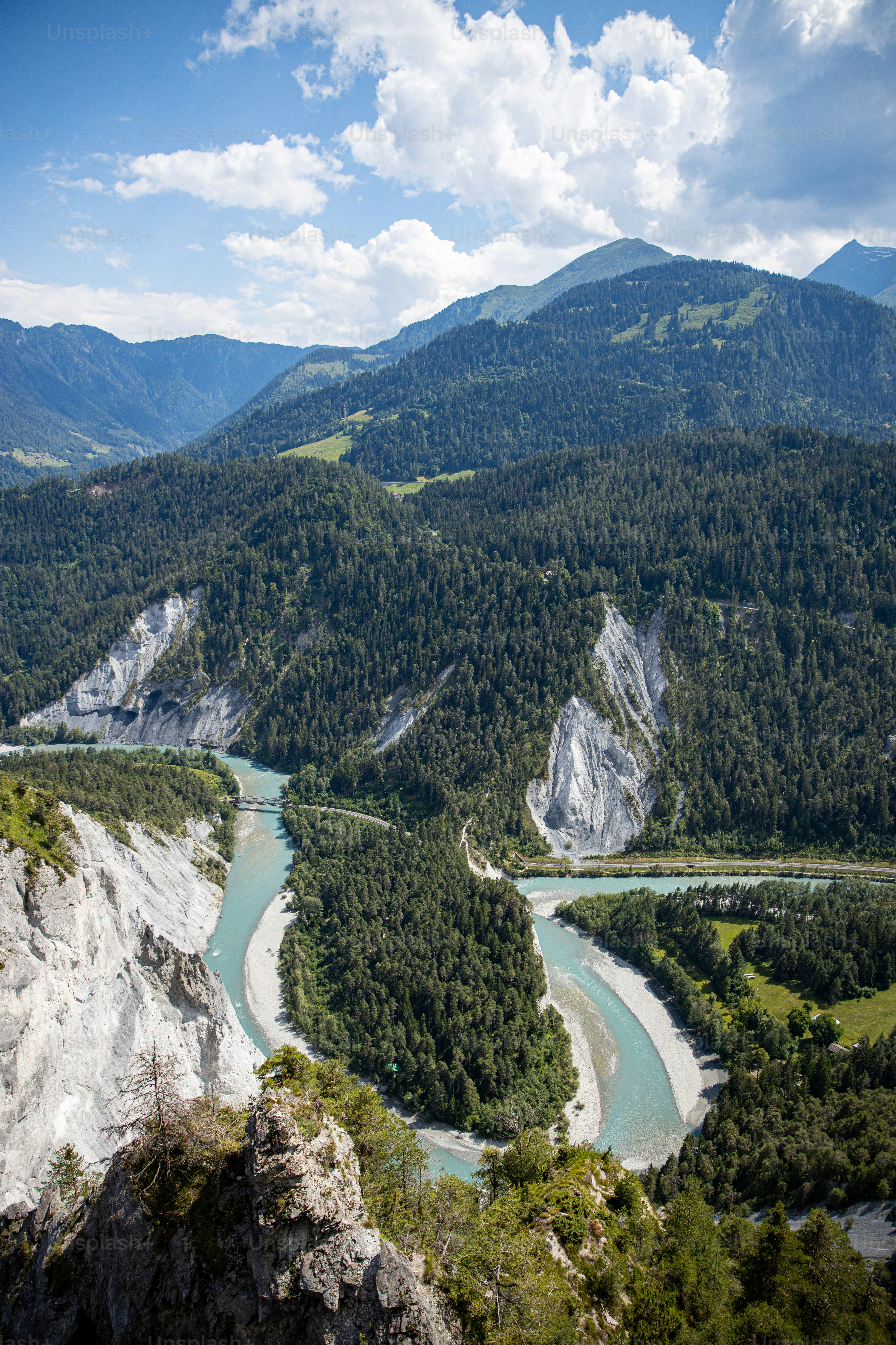 a river running through a valley surrounded by mountains