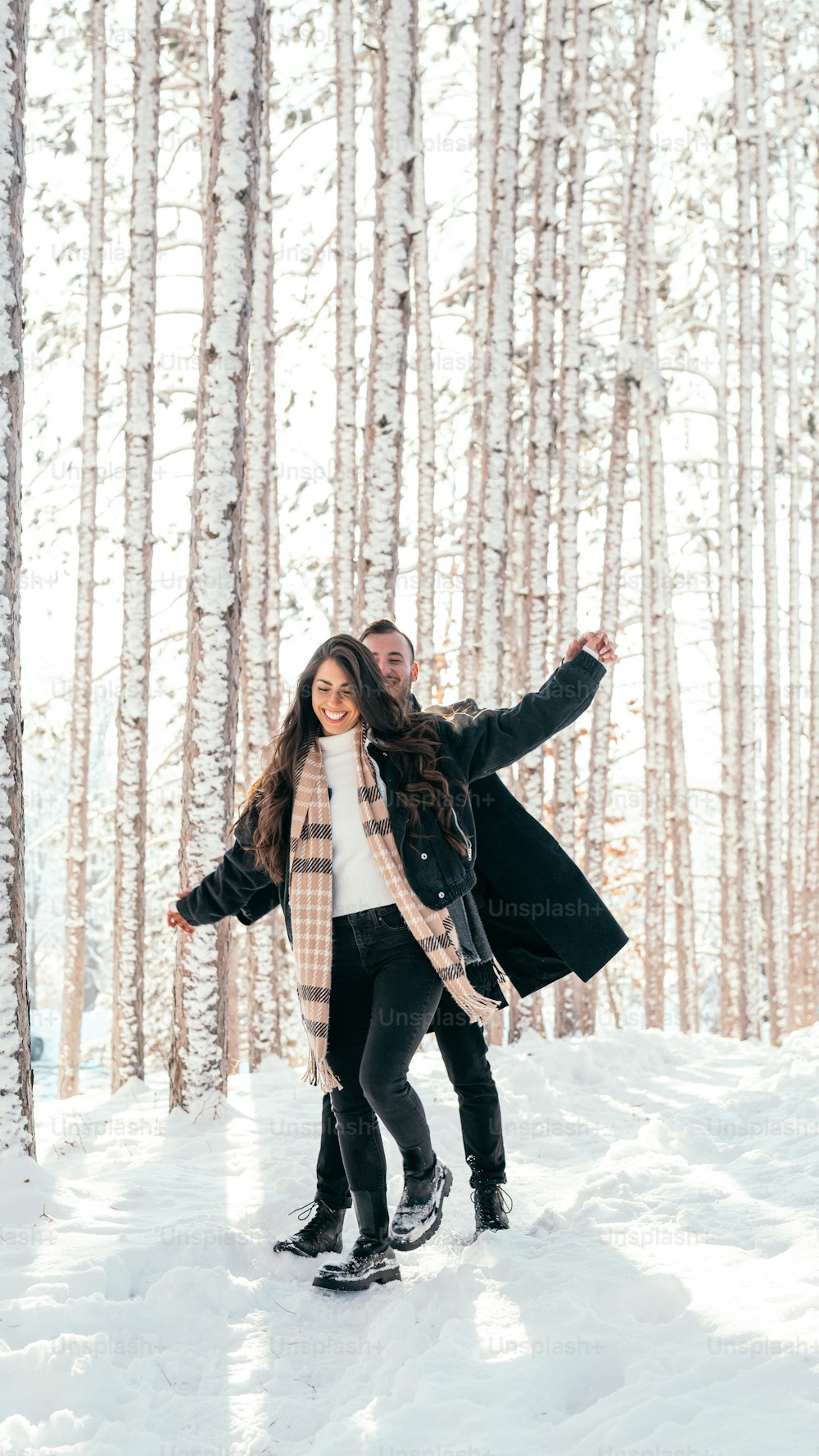 a man and a woman are standing in the snow