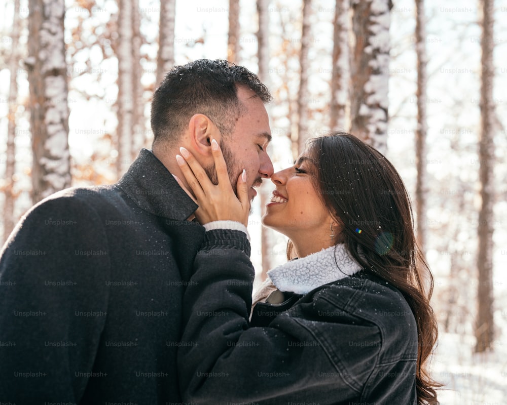 um homem e uma mulher se beijando na neve