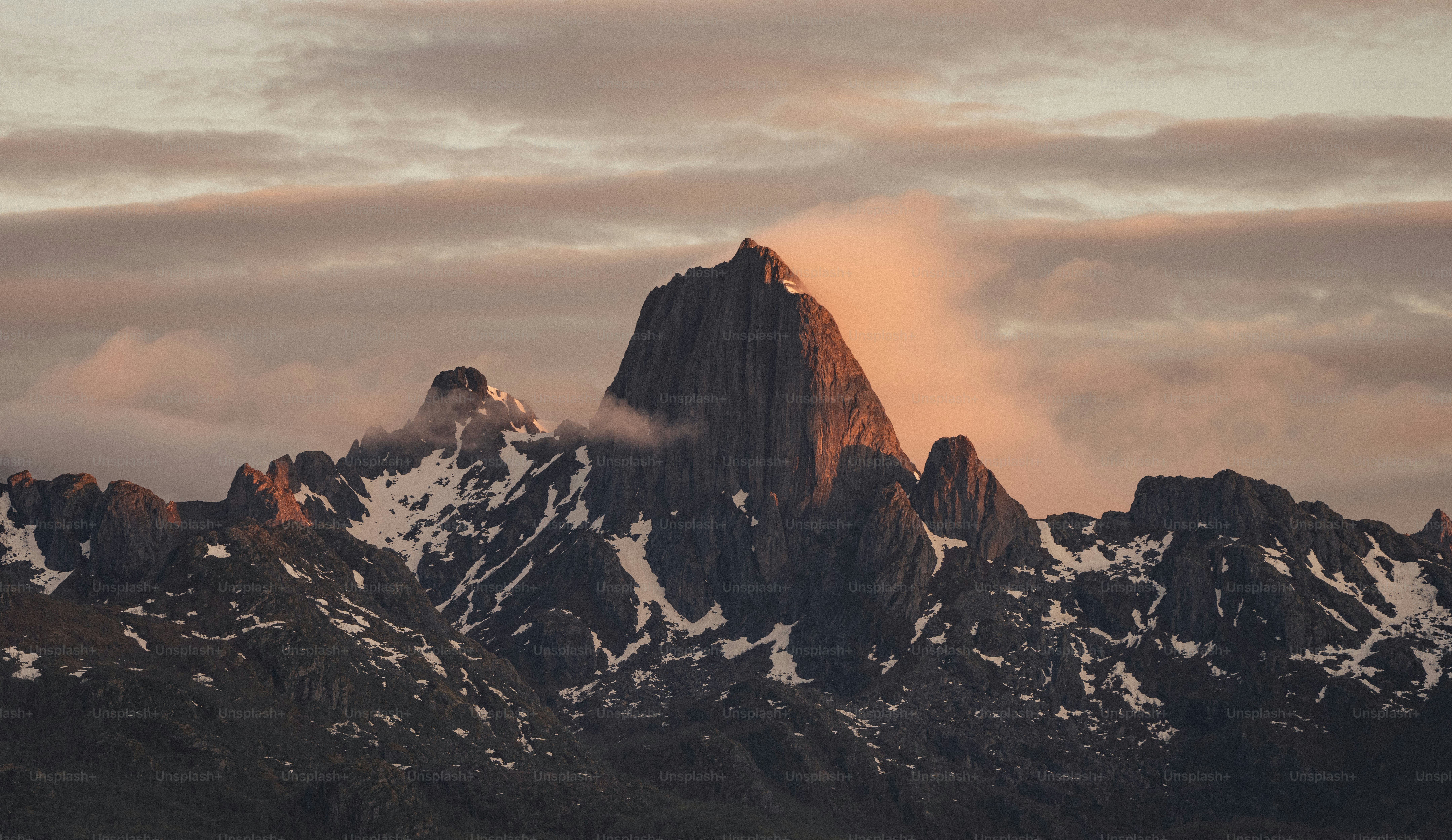 A very tall mountain covered in snow under a cloudy sky photo – Norway ...