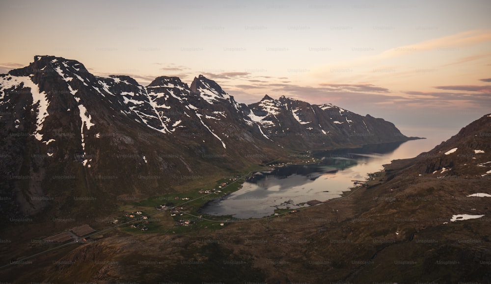 Una vista aérea de una cadena montañosa con un lago en primer plano