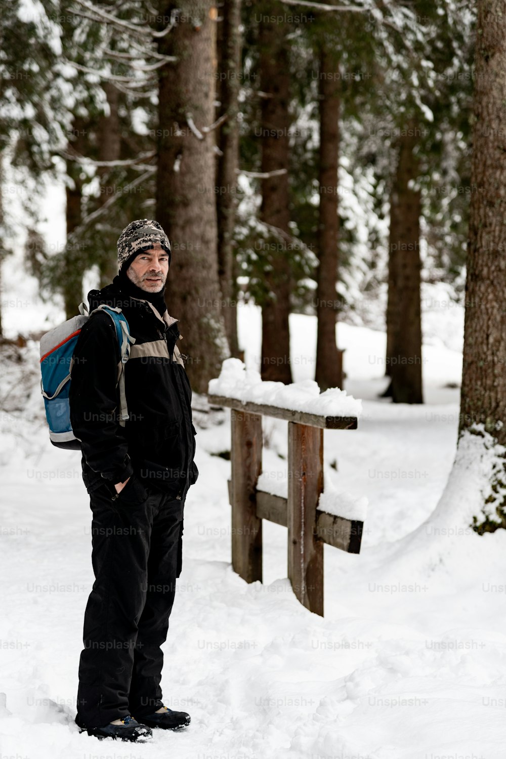 um homem com uma mochila em pé na neve