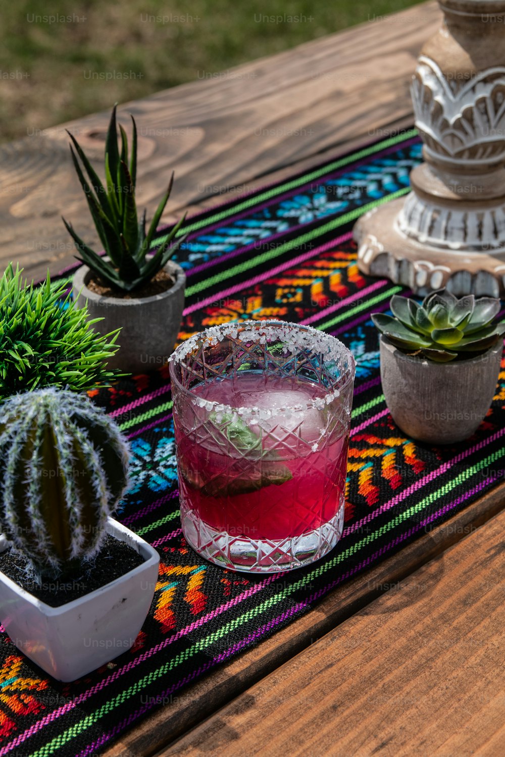 a wooden table topped with plants and a drink