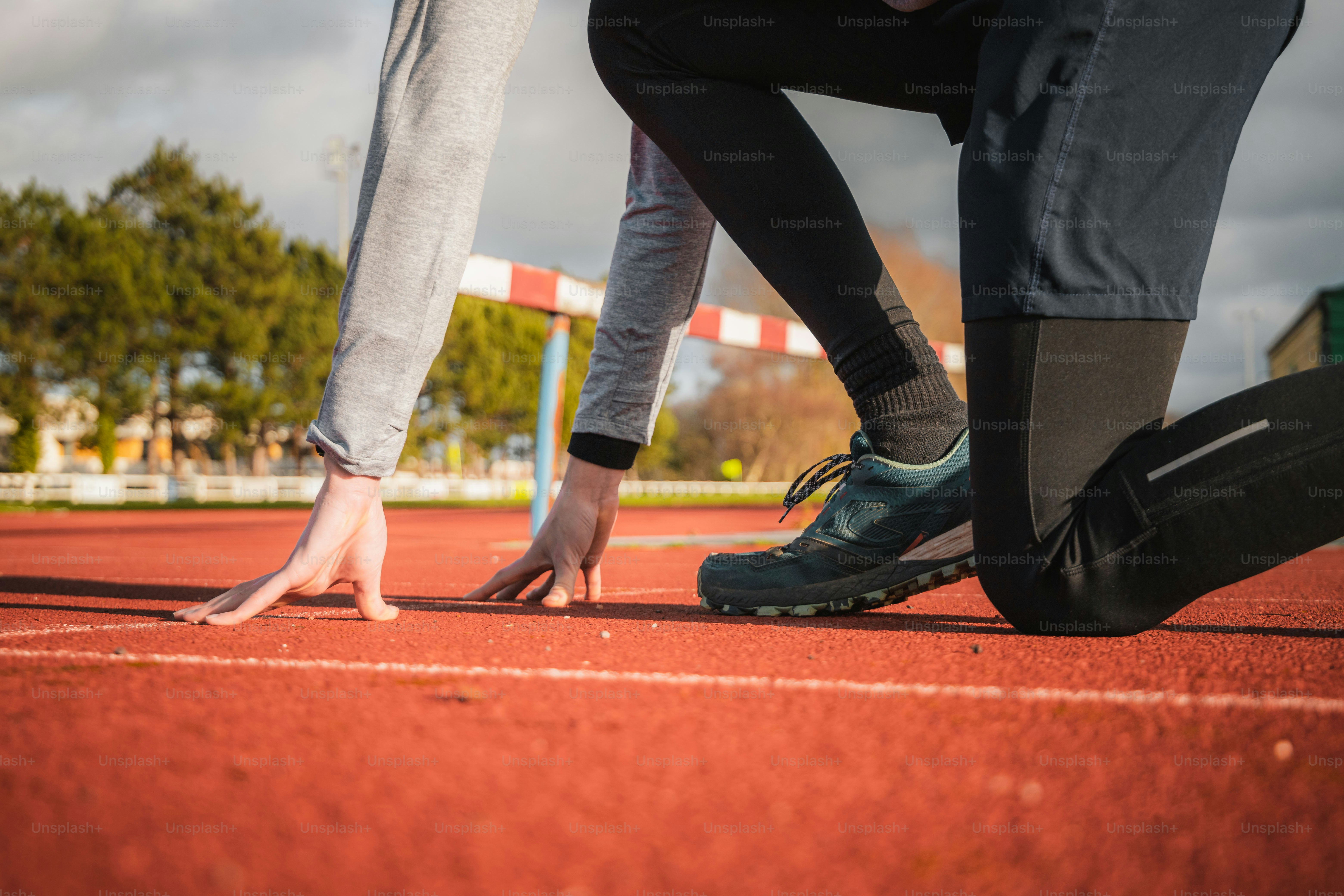 a couple of people standing on top of a red tennis court