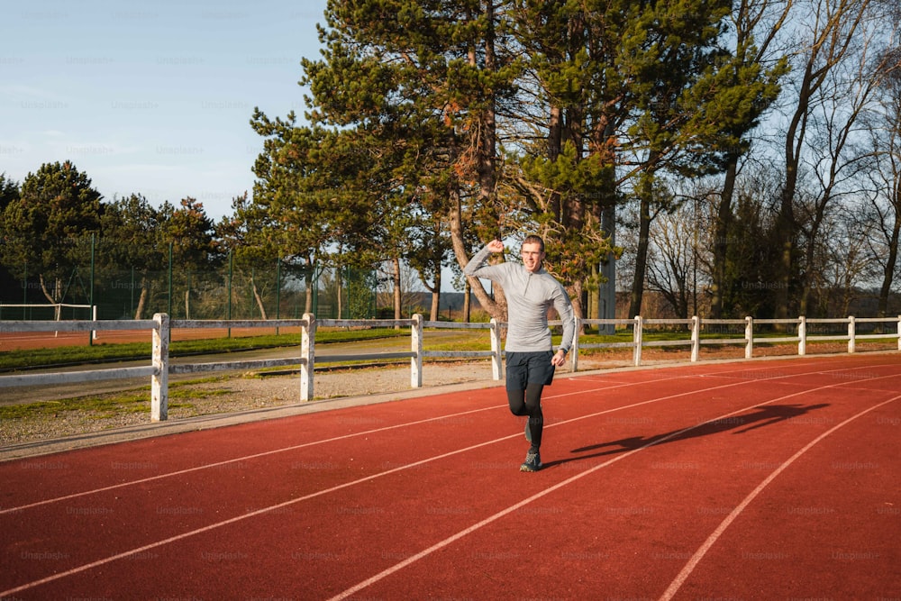 a man running on a track with trees in the background