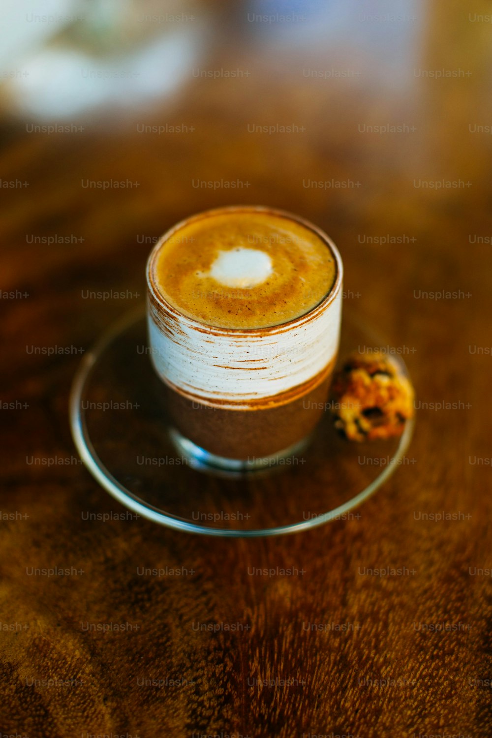 a cappuccino sitting on a saucer on a wooden table