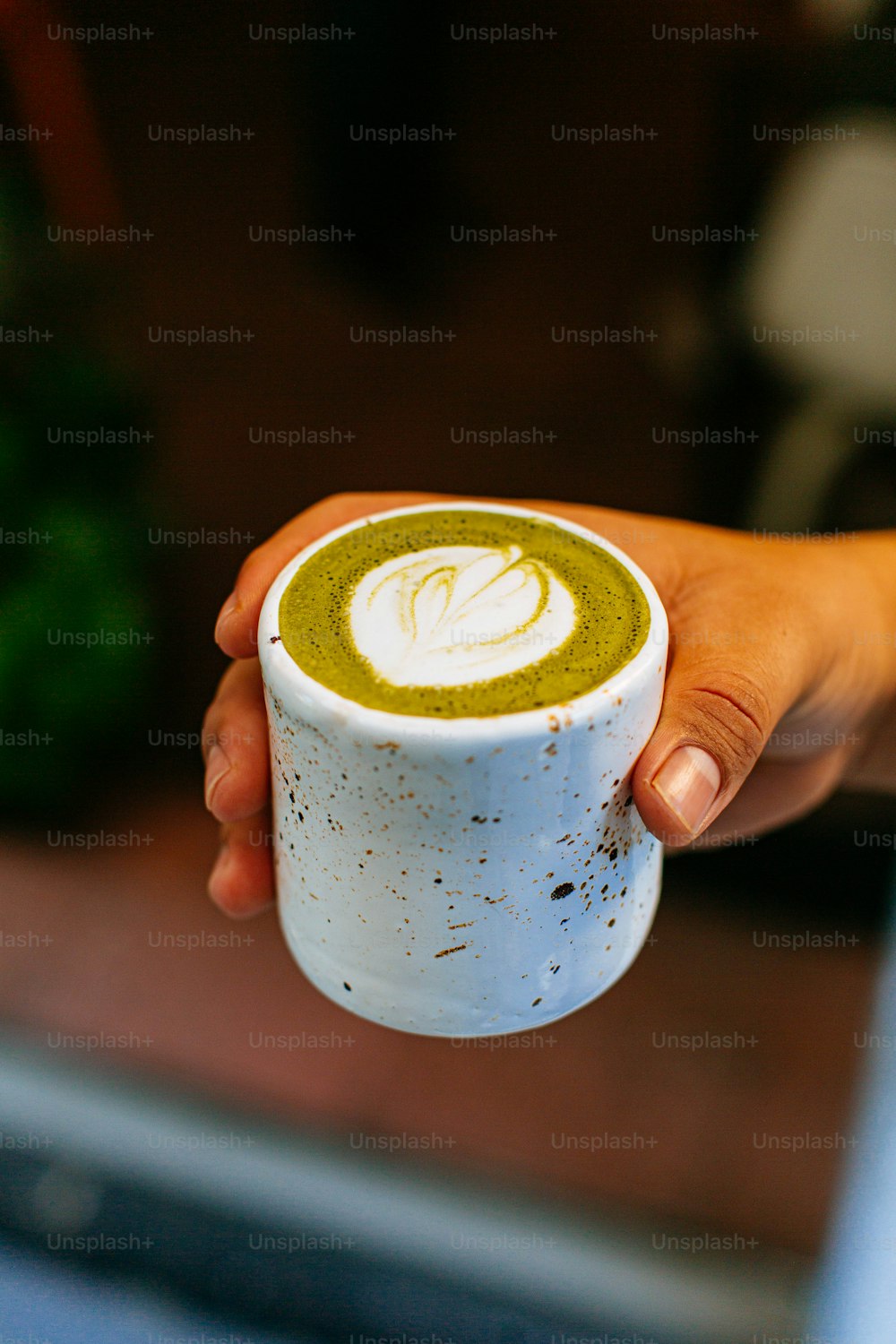 a person holding a cup of green tea