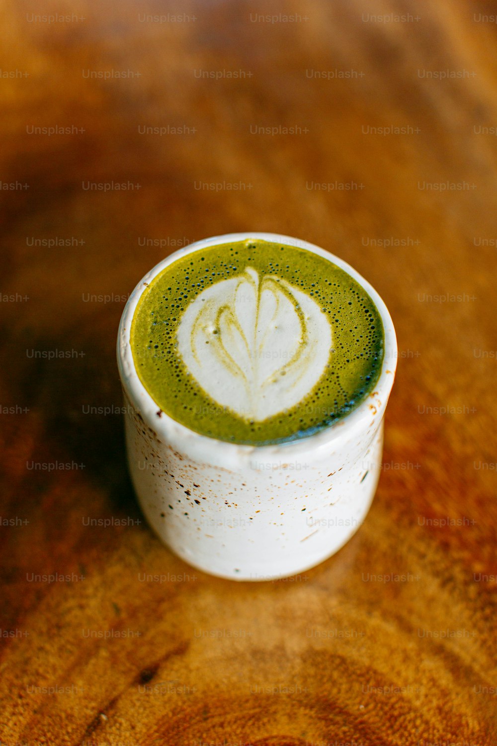 木のテーブルの上の緑茶のカップ