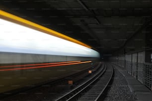 uma foto borrada de um trem passando por um túnel