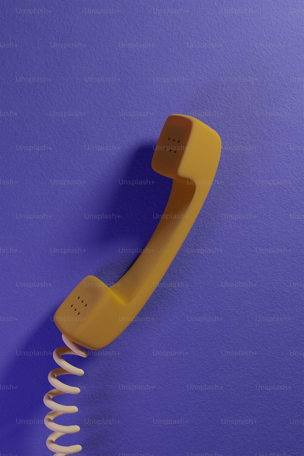 Un telefono giallo su uno sfondo viola