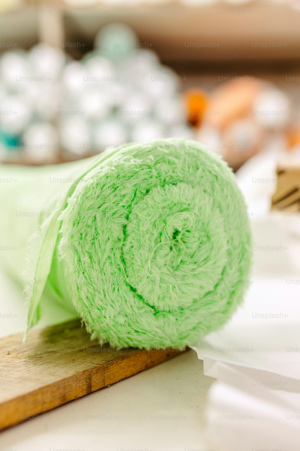 a roll of green cloth sitting on top of a wooden board