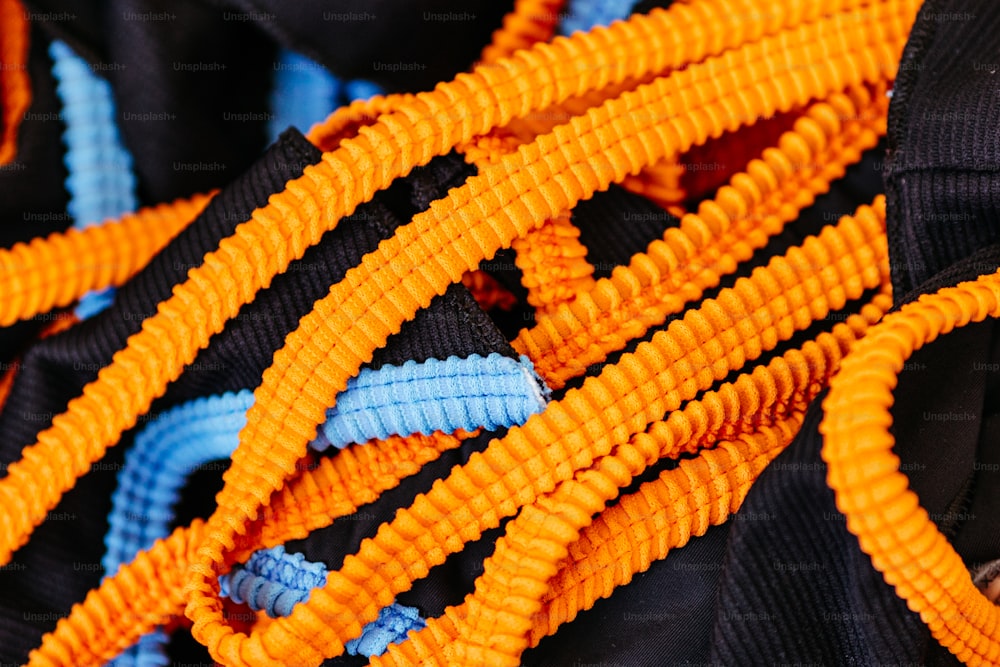 Un primer plano de un montón de cuerdas naranjas y azules