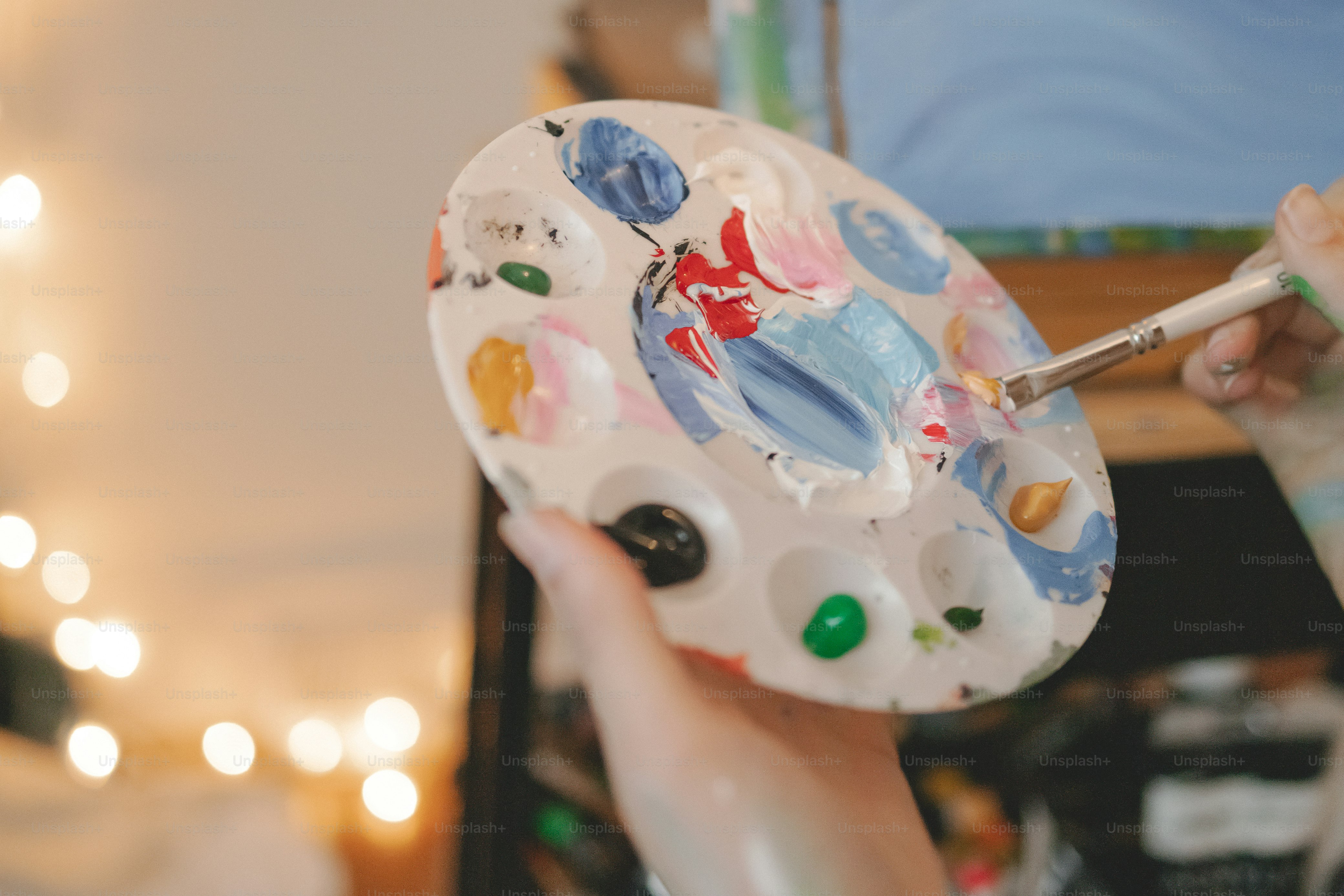 손에 붓을 들고 페인트 팔레트를 들고 있는 사람