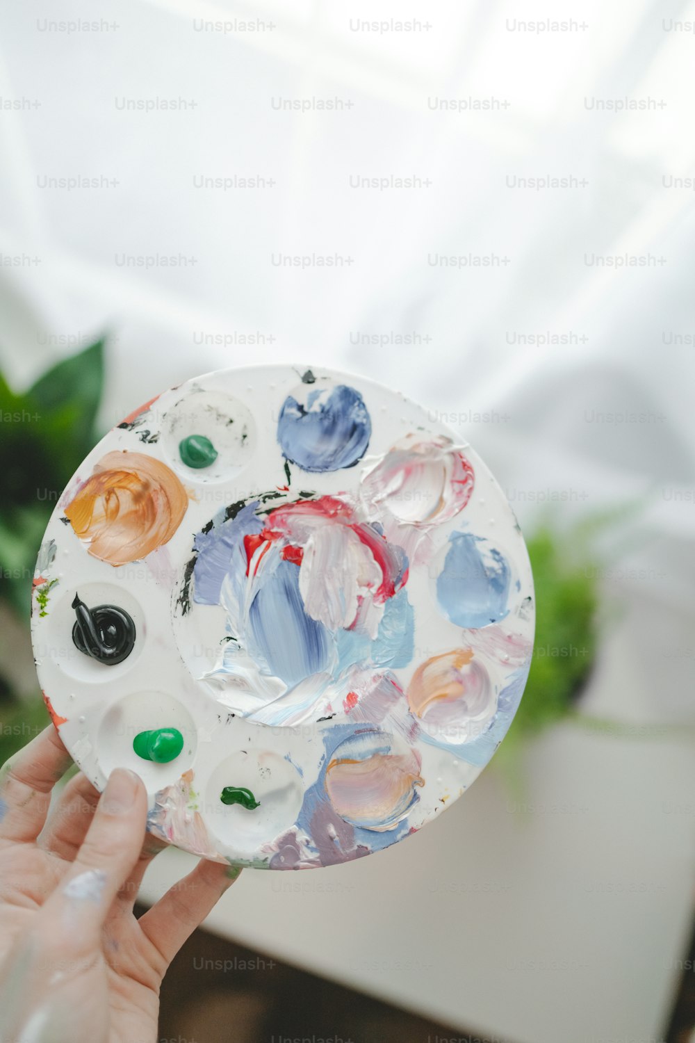 a person holding a plate with paint on it