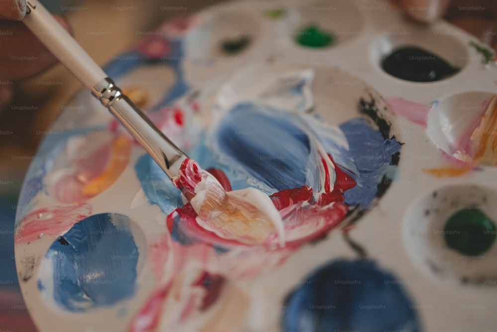 a close up of a paint palette with a brush