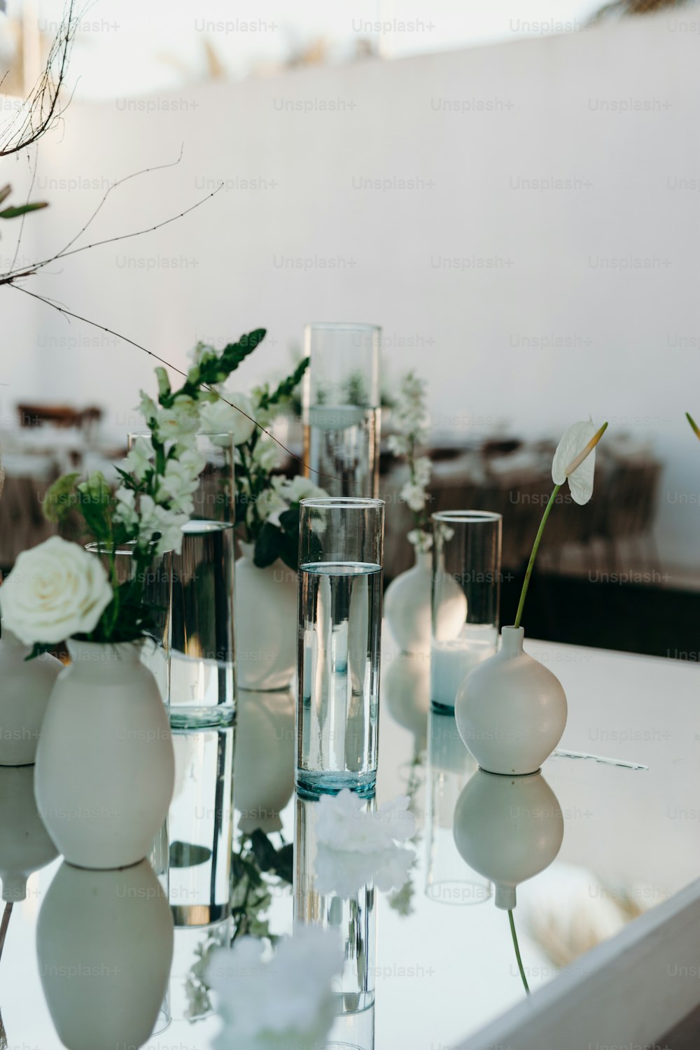 꽃병으로 가득 찬 흰색 테이블