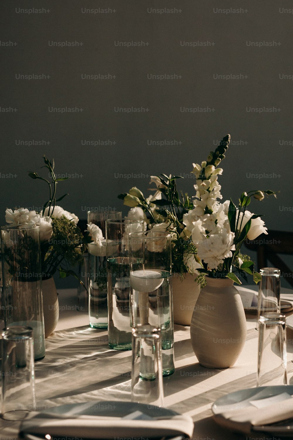 a table topped with vases filled with white flowers