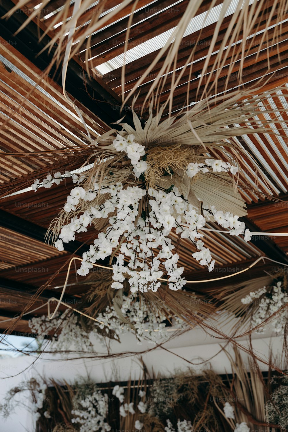 a bunch of white flowers hanging from a ceiling