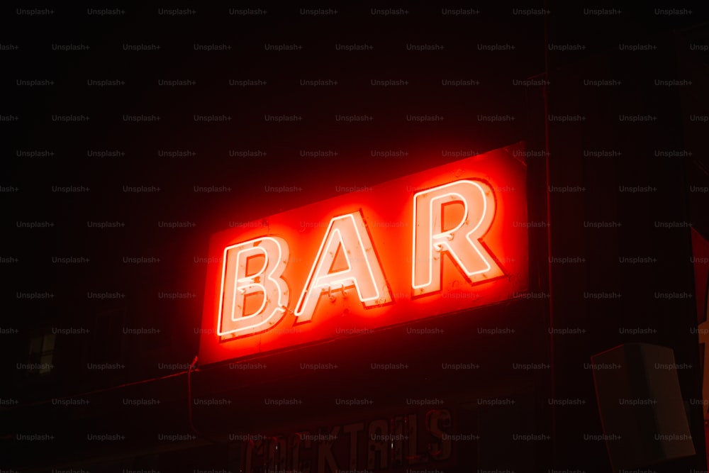a bar sign lit up in the dark