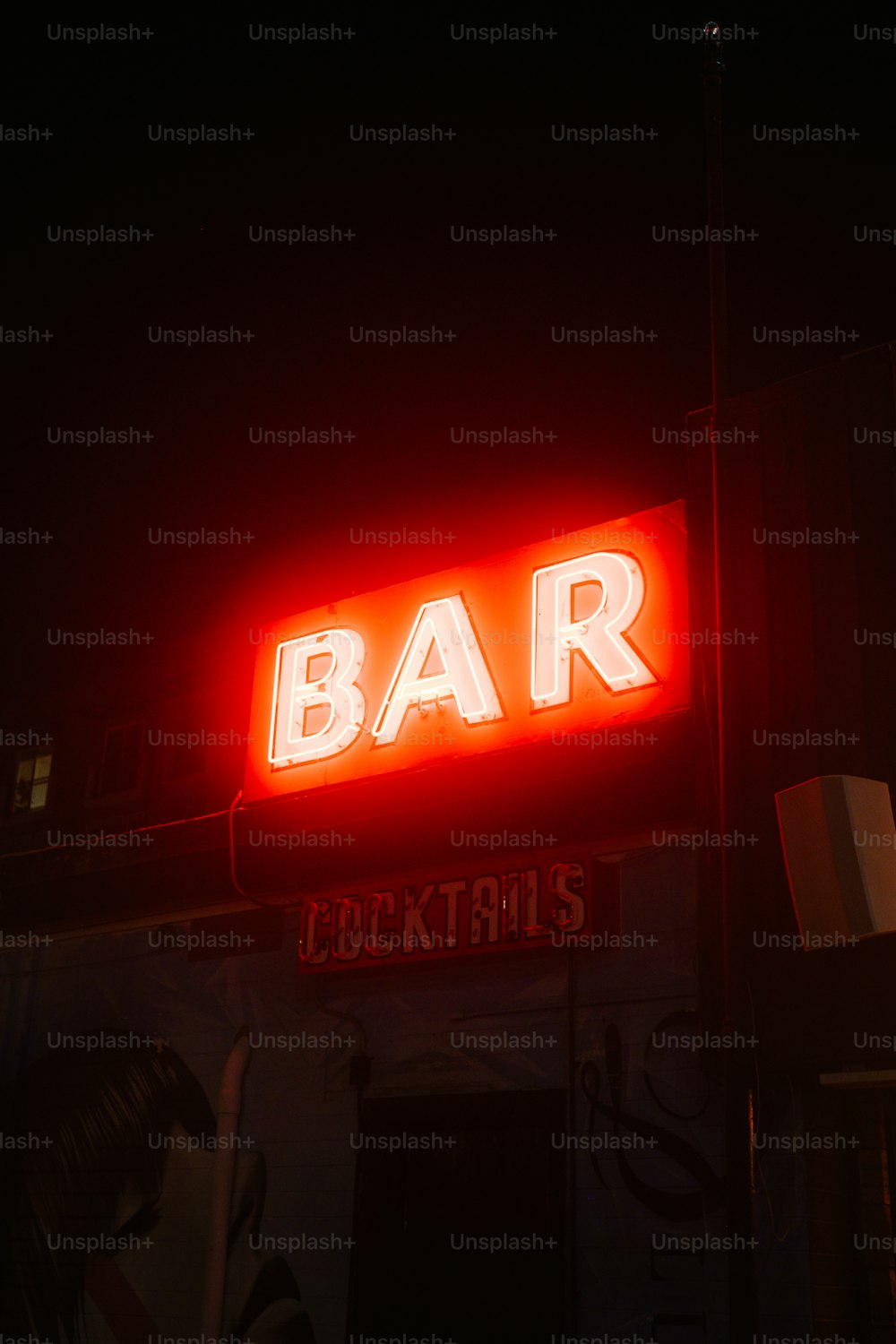uma placa de bar iluminada no escuro