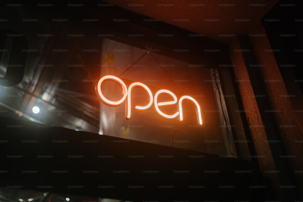 a neon sign that reads open on a window