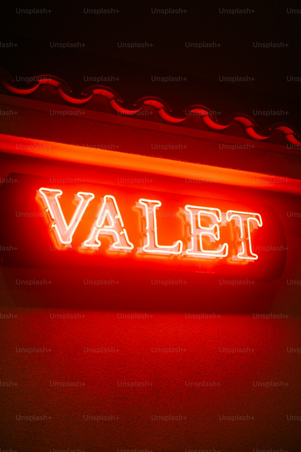 a red neon sign that says valet on it