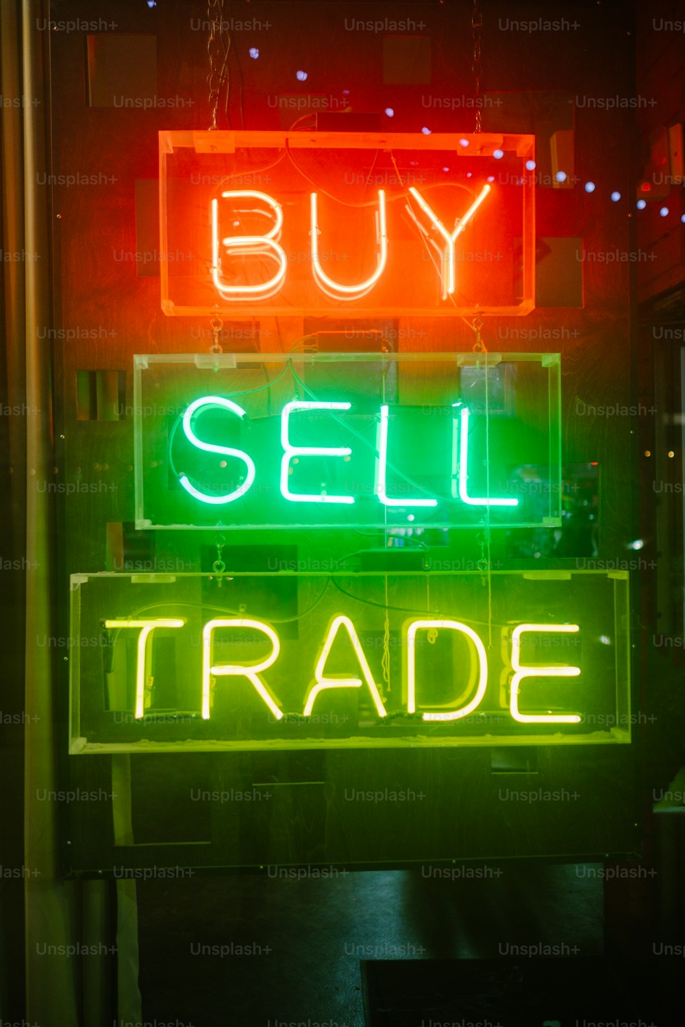 a neon sign that says buy sell trade