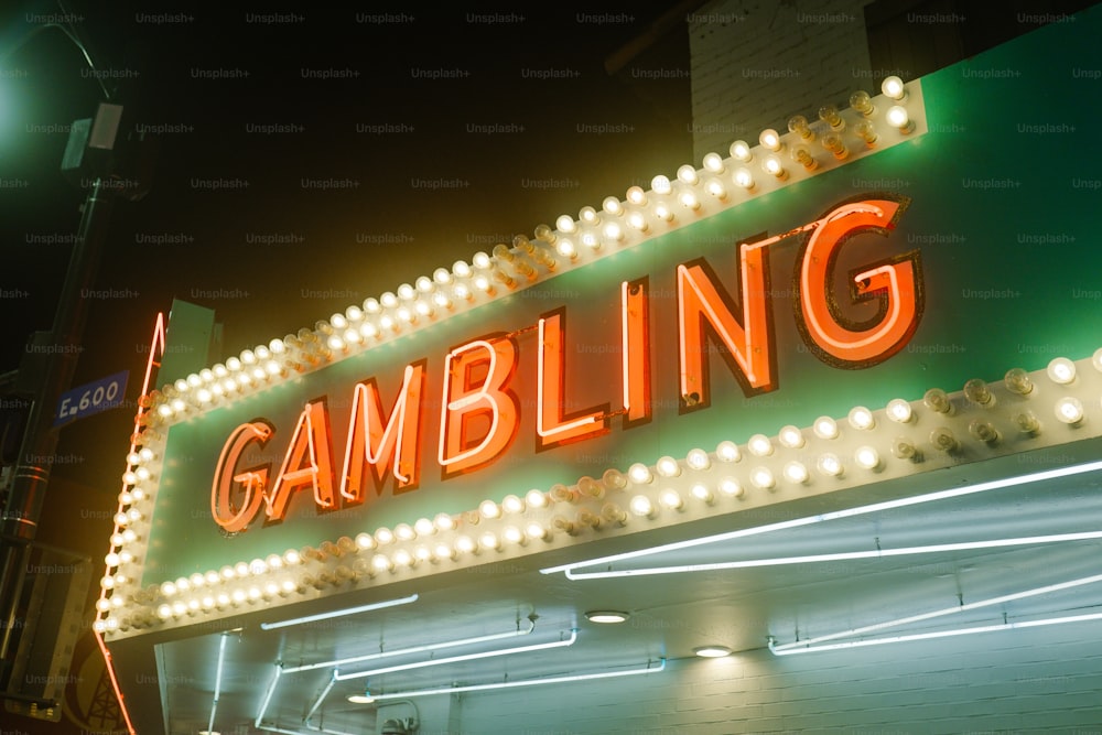 a neon sign that reads gambling on a building