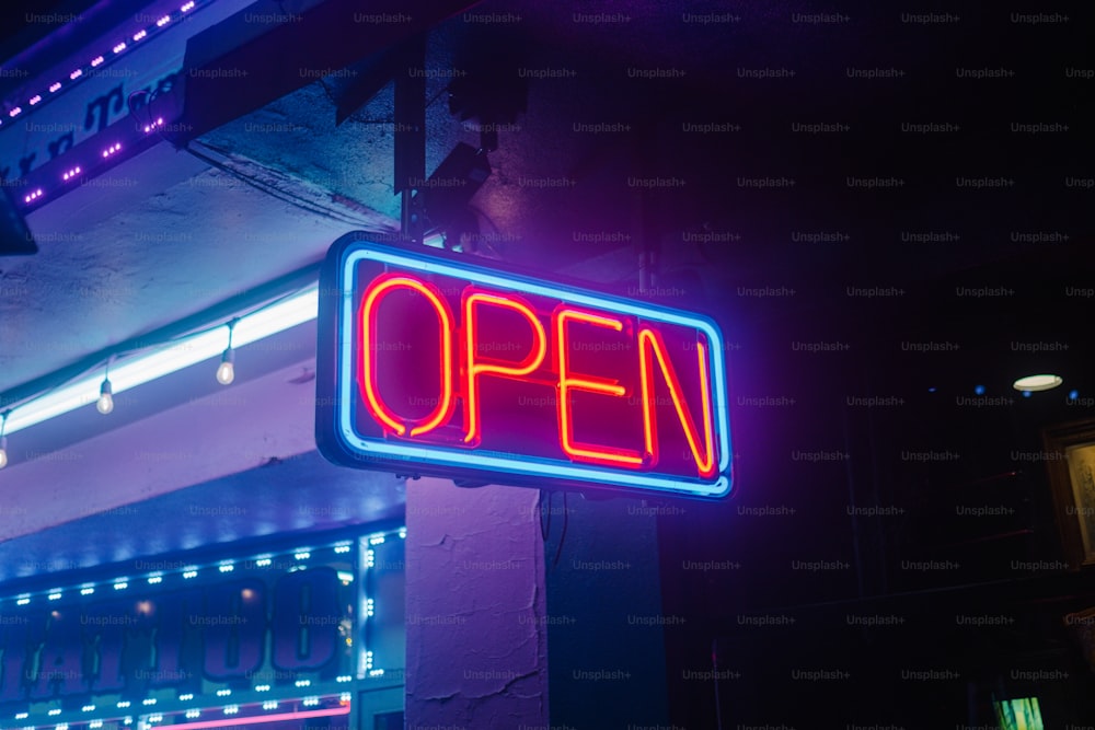 a neon sign that says open on the side of a building