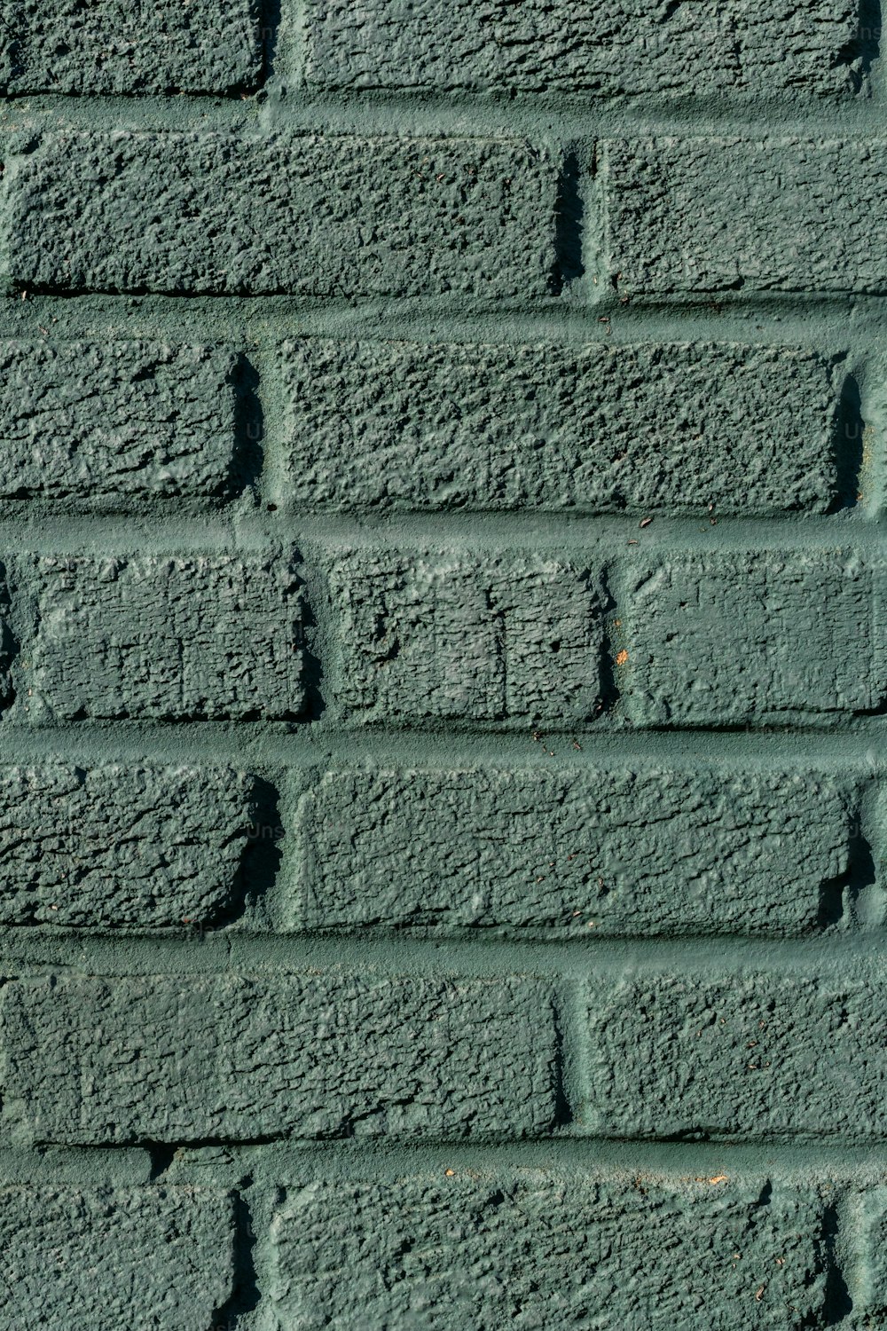 a close up of a green brick wall