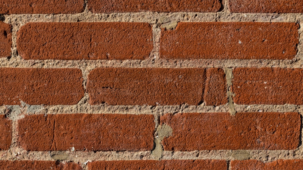 Un primo piano di un muro di mattoni fatto di mattoni rossi
