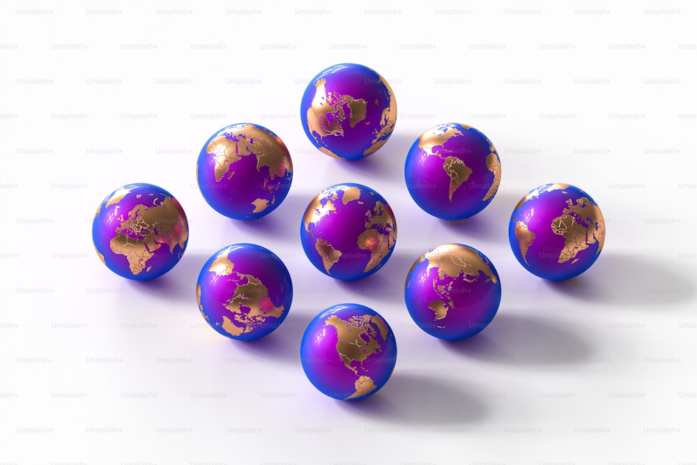 Un montón de bolas púrpuras y doradas sobre una superficie blanca