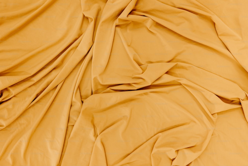 a close up of a bed with yellow sheets
