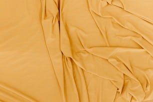 eine Nahaufnahme eines Bettes mit gelben Laken
