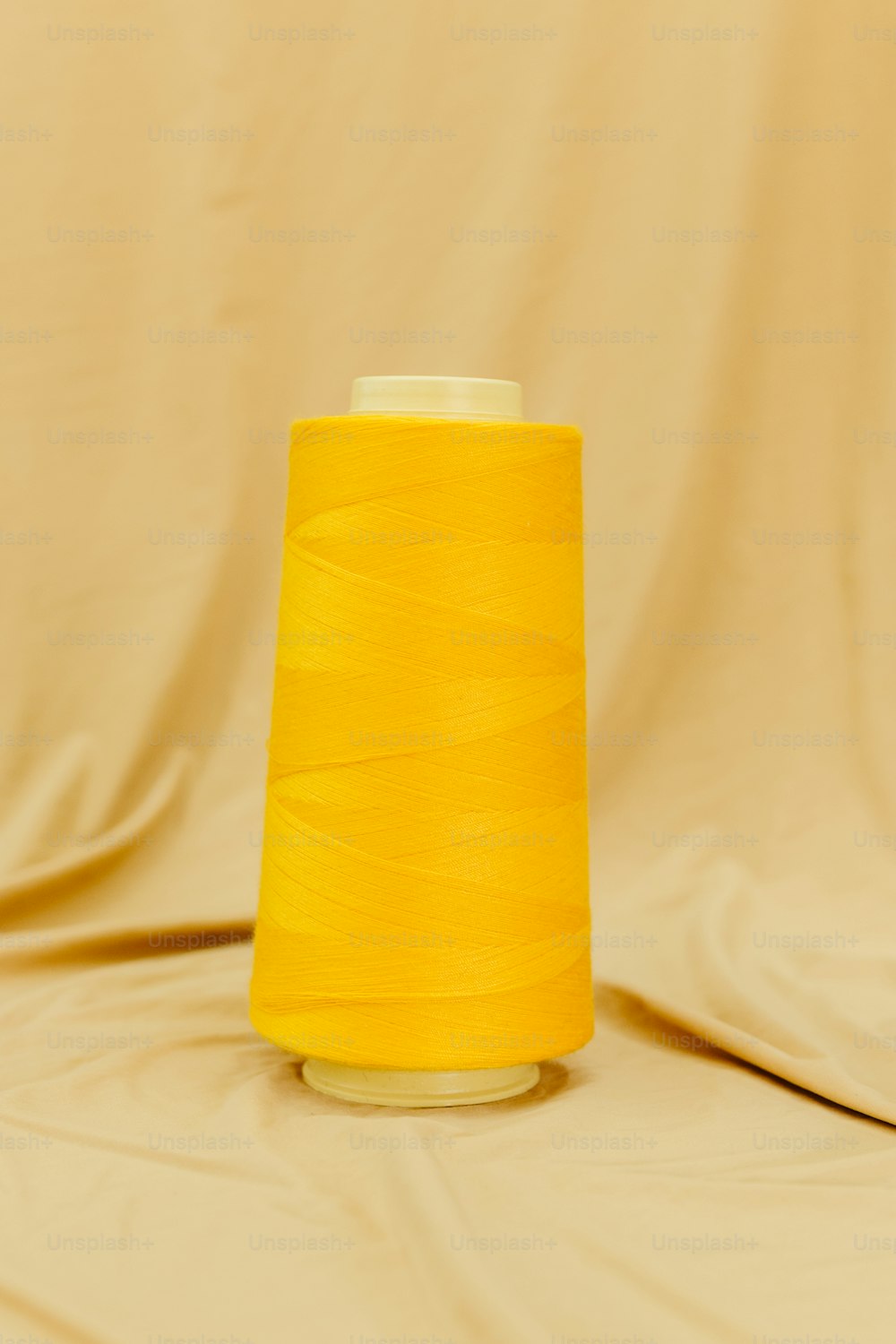 a yellow spool of thread sitting on top of a table