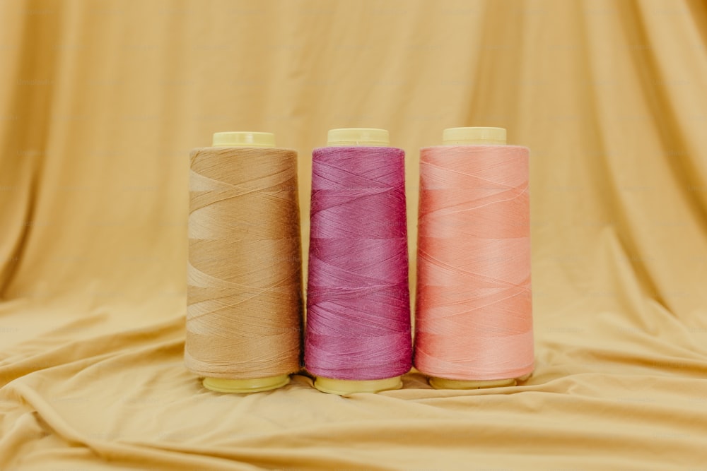 three spools of thread sitting next to each other
