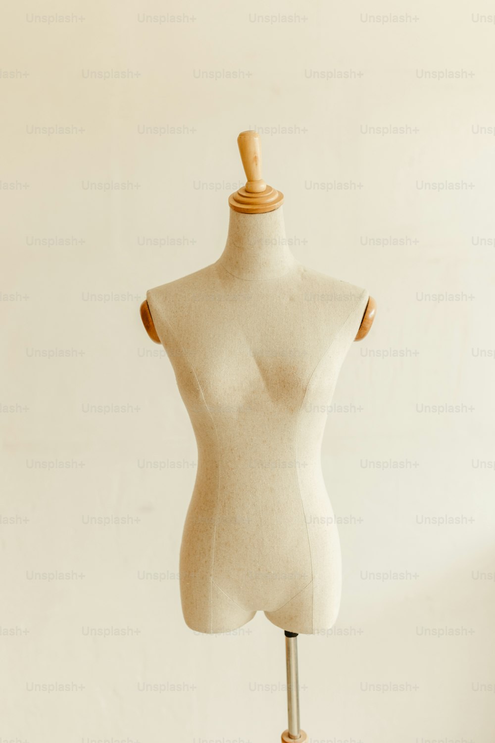 a white mannequin on a wooden stand