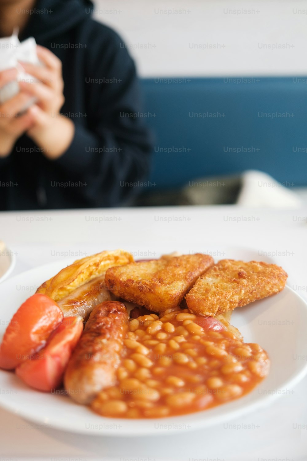 une personne assise à une table avec une assiette de nourriture