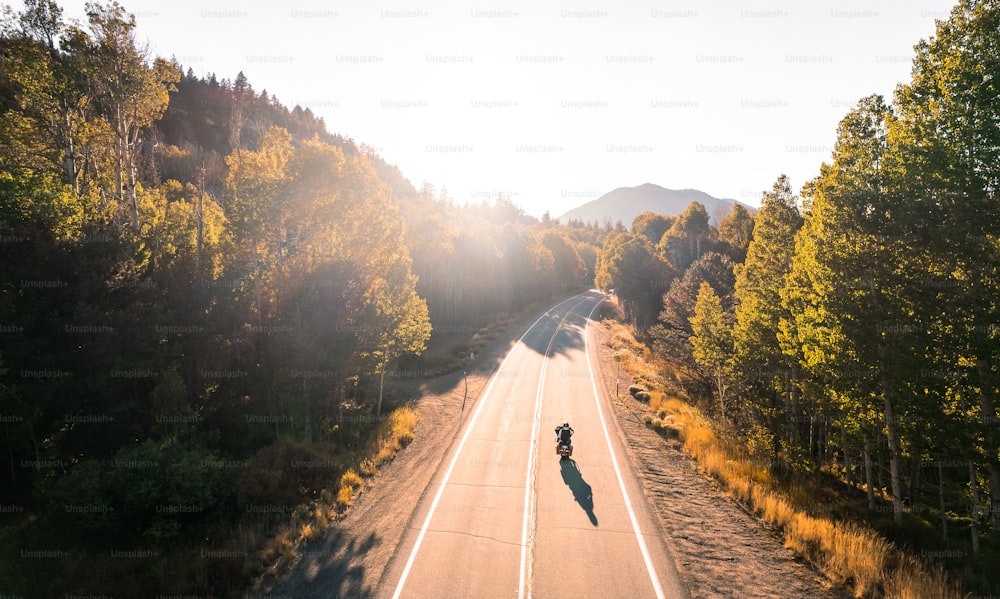 a person riding a motorcycle down the middle of a road