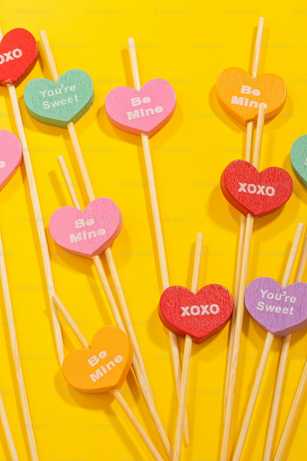 heart shaped lollipops on a yellow background