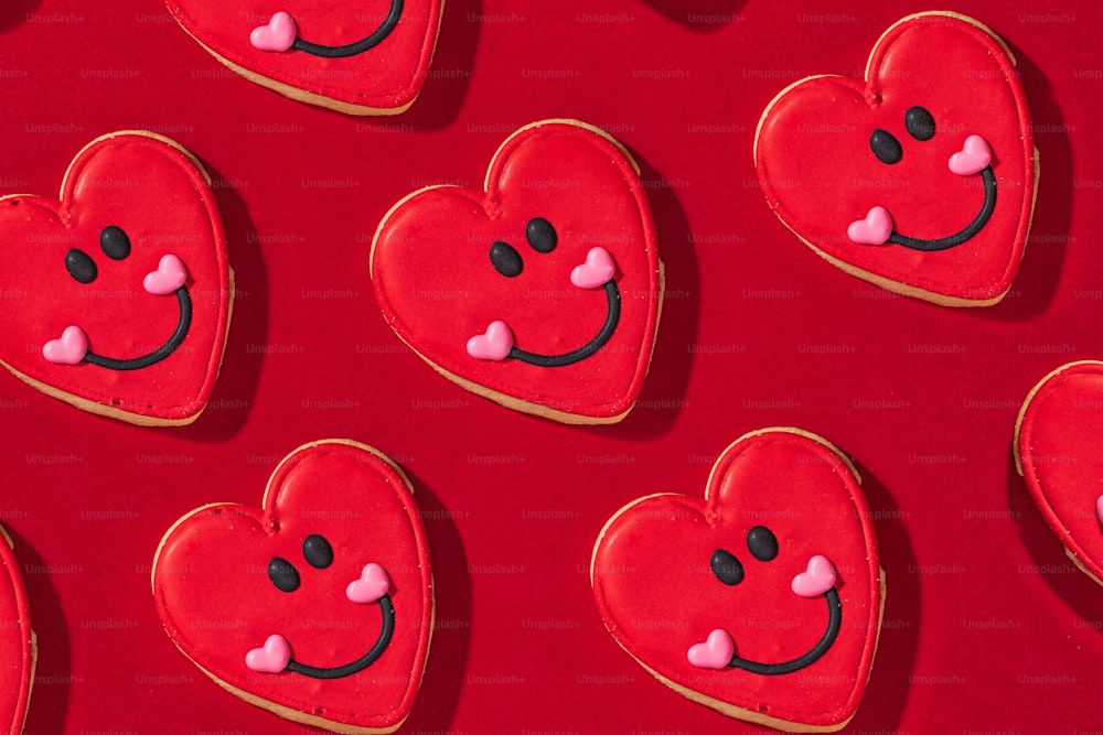 Galletas en forma de corazón dispuestas sobre una superficie roja