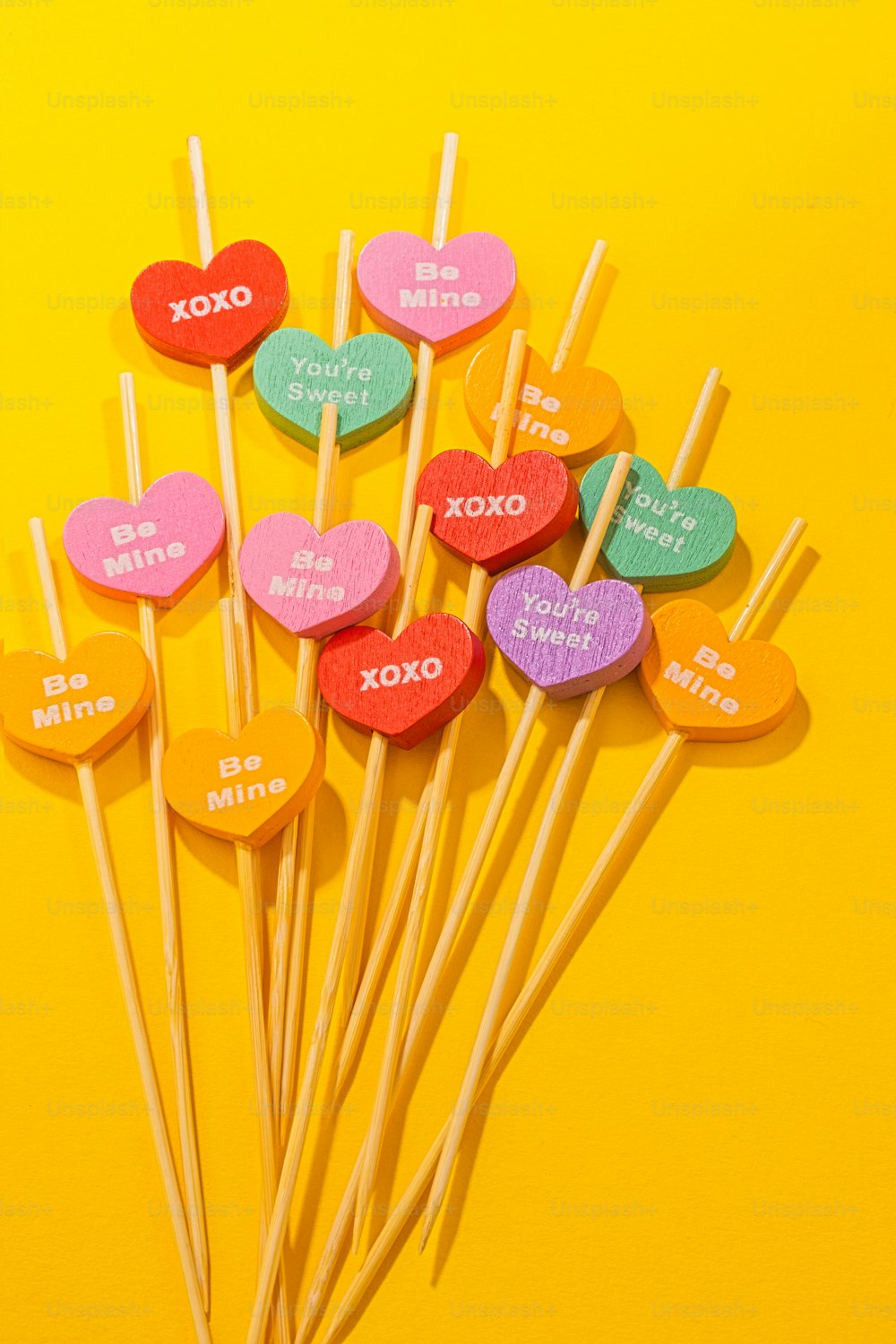 heart shaped lollipops on a yellow background